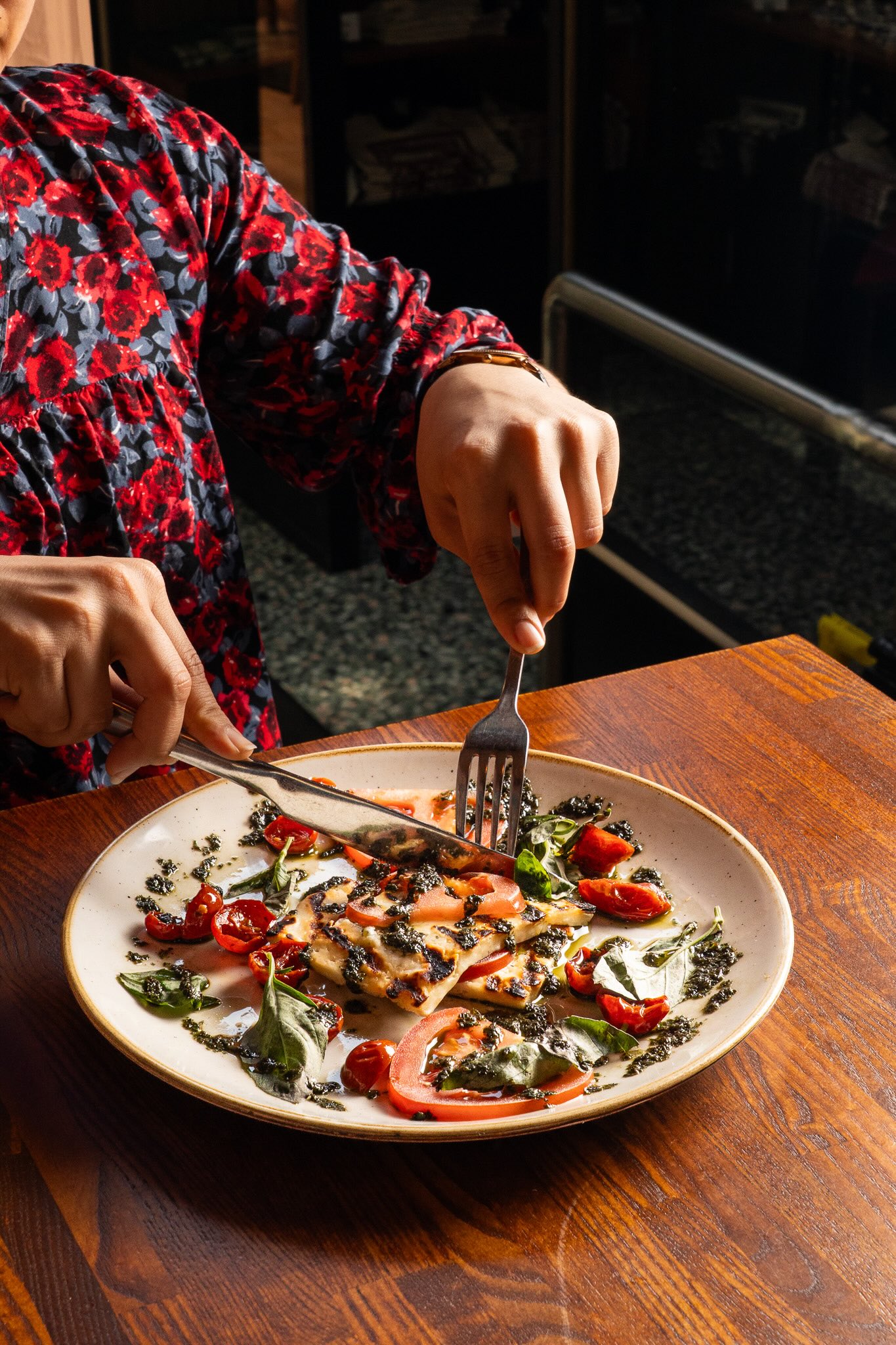 Grilled halloumi and tomato dish photographed on a restaurant table in natural light